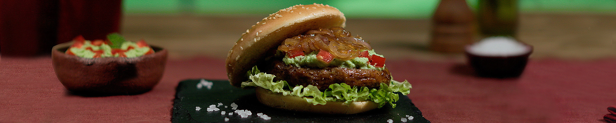 Panino con burger vegetale cipolle caramellate guacamole e insalata