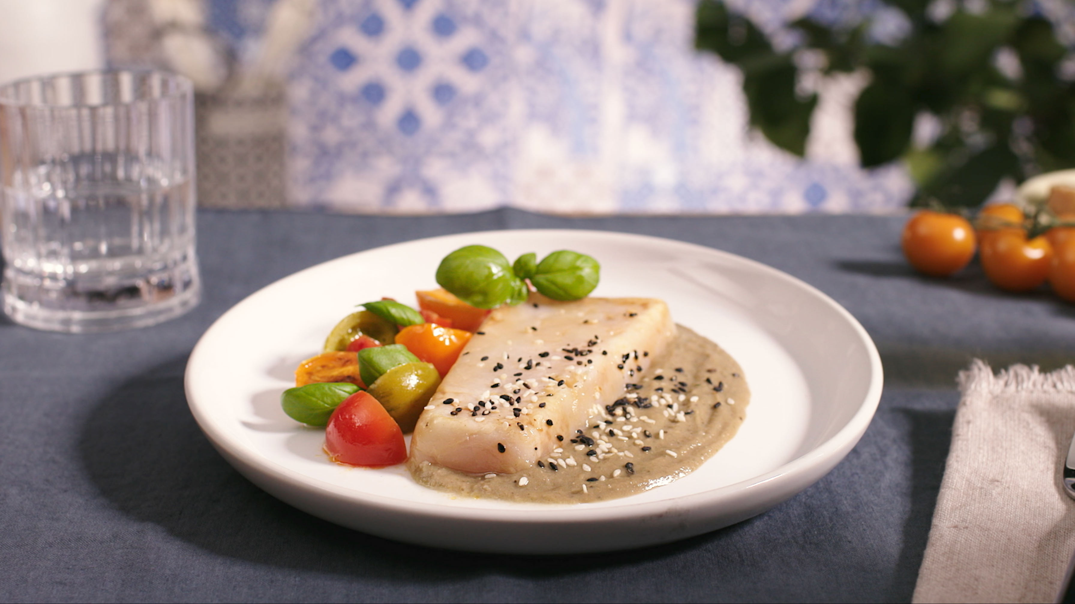Filetti di merluzzo con crema di melanzane, sesamo e pomodorini